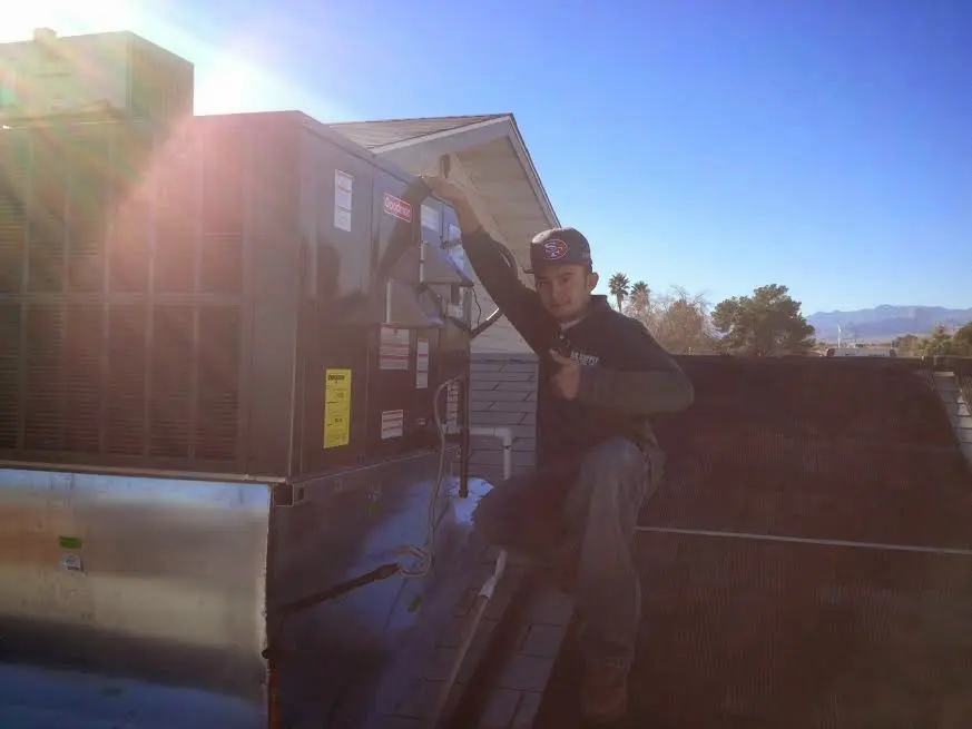 HVAC technician performing Air Duct Cleaning on a rooftop unit in San Lorenzo